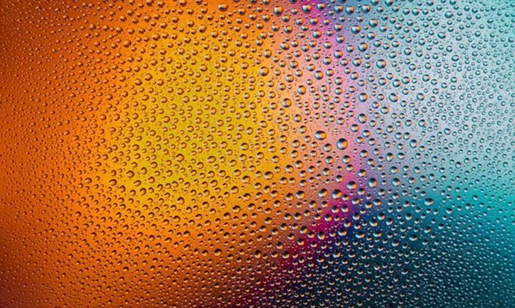 Raindrops on glass in front of a colorful gradient. Structuring your ayahuasca microdosing routine.